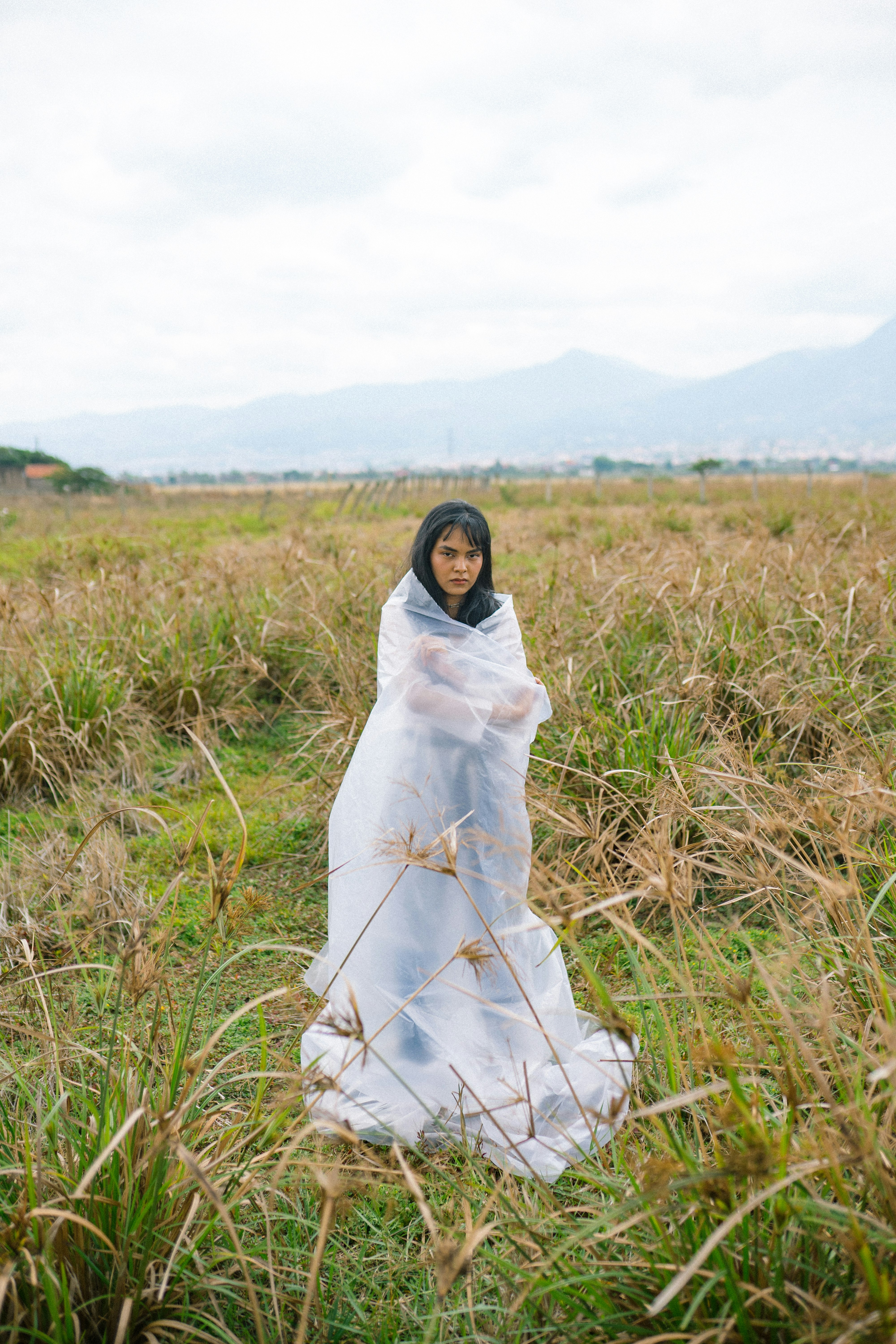 woman in white dress standing on green grass field during daytime